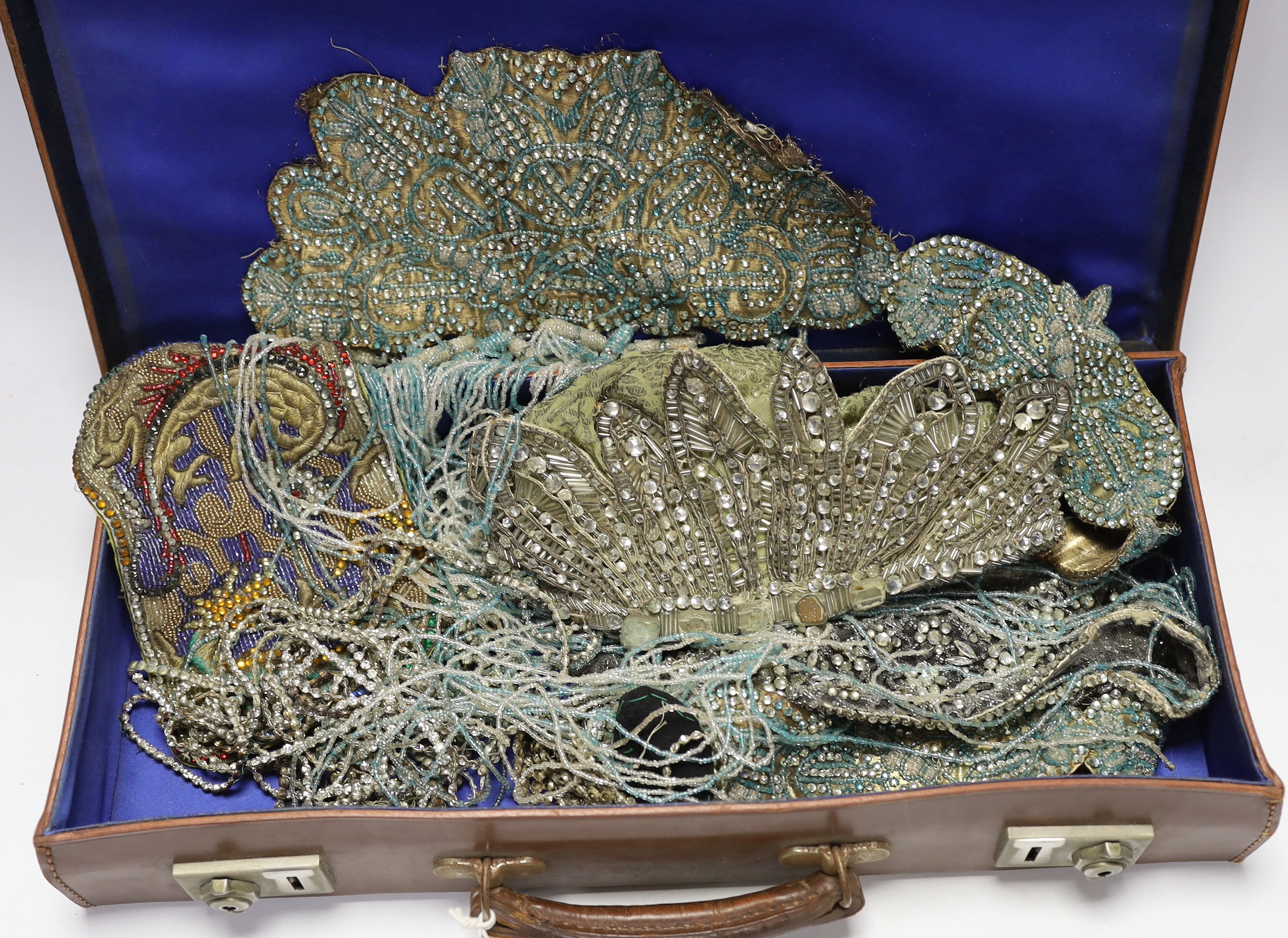 A 1920’s flapper coloured beaded and fringed appliqués and a diamanté appliquéd hat in a small leather case